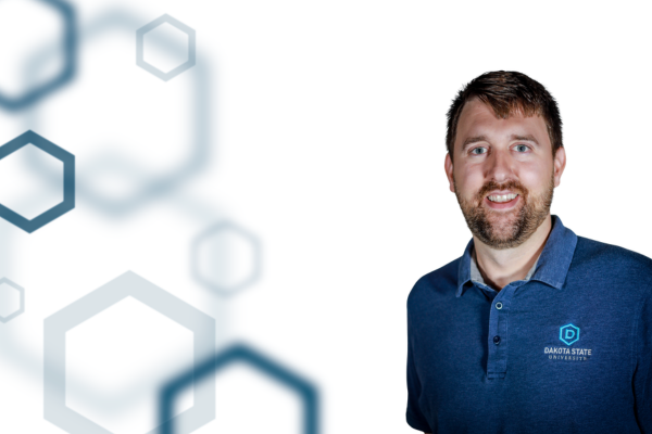 Dr. Andrew Sathoff on the right with a white background and navy hexagons on the left side. 